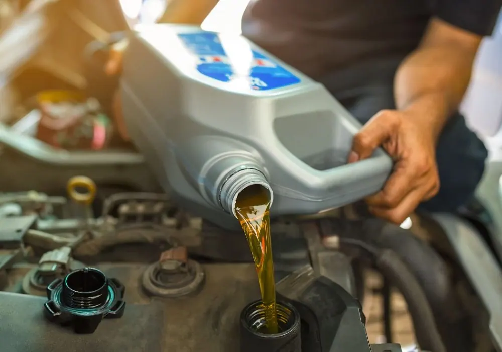 Car,Mechanic,Replacing,And,Pouring,Fresh,Oil,Into,Engine,At