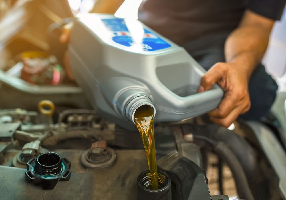 Car,Mechanic,Replacing,And,Pouring,Fresh,Oil,Into,Engine,At