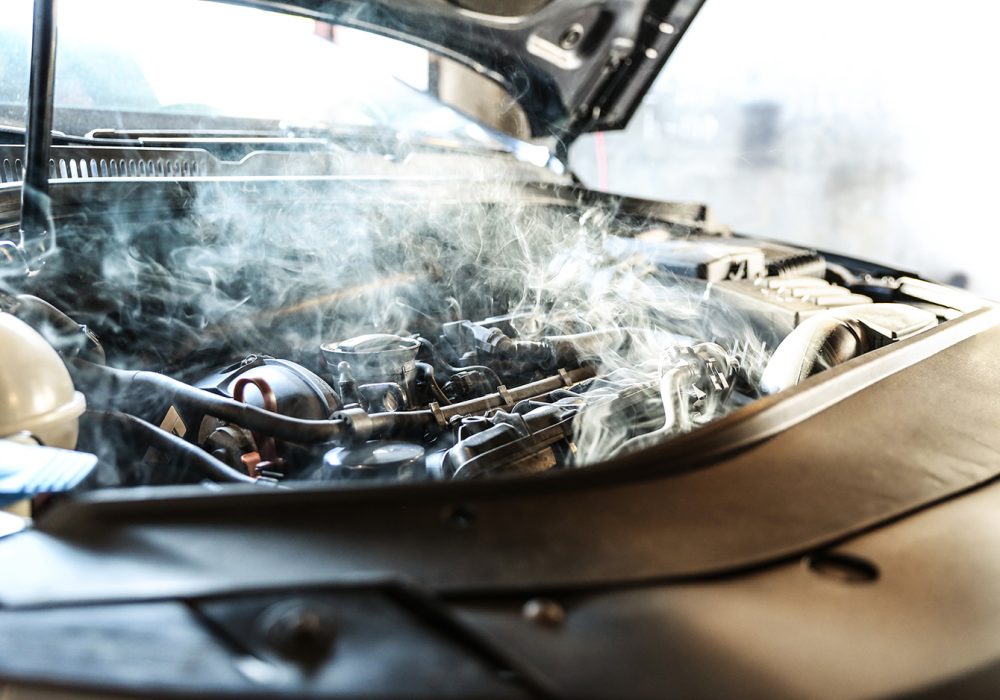 car engine overheating close up. vehicle engine in smoke. short circuit in the car motor. car wiring fault. smoke or steam from a vehicle engine